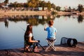 Two young cute little friends, boy and girl fishing on a lake in a sunny summer day Royalty Free Stock Photo