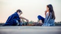 Two young cute little friends, boy and girl having fun while playing chess sitting by the lake in the evening Royalty Free Stock Photo