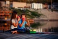 Two young cute little friends, boy and girl talking, drinking tea, eating sandwiches and fishing on a lake in a sunny summer day Royalty Free Stock Photo