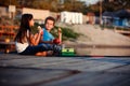 Two cute little friends, boy and girl talking, drinking tea, eating sandwiches and fishing on a lake in a sunny summer day Royalty Free Stock Photo