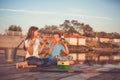 Two young cute little friends, boy and girl talking, drinking tea, eating sandwiches and fishing on a lake in a sunny summer day Royalty Free Stock Photo