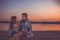 Two young cute little friends, boy and girl talking and drinking tea while sitting covered with blanket. sunset Royalty Free Stock Photo