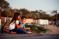 Two young cute little friends, boy and girl talking, eating sandwiches and fishing on a lake in a sunny summer day Royalty Free Stock Photo