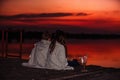 Two young cute little friends, boy and girl talking while sitting covered with blanket during sunset Royalty Free Stock Photo