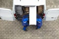 Two Delivery Men Unloading Furniture From Vehicle Royalty Free Stock Photo