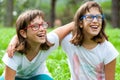 Two young disabled kids laughing outdoors.