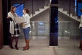 Two young elegant and attractive female colleagues met in the hall and now cheerfully chatting. Business, inside, work Royalty Free Stock Photo