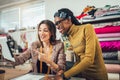 Young entrepreneur women, or fashion designers working in atelier, using digital tablet