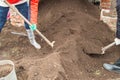 Two young farmer man and woman working in the garden, digging the soil with a shovel Royalty Free Stock Photo