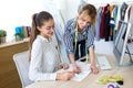 Two young fashion designers deciding on the designs of the new collection of clothes in the sewing workshop Royalty Free Stock Photo