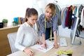 Two young fashion designers deciding on the designs of the new collection of clothes in the sewing workshop Royalty Free Stock Photo