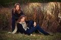 Two young fashion girls in black pullover and dark blue jeans outdoor Royalty Free Stock Photo