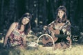 Two young fashion girls with fruit baskets in summer forest Royalty Free Stock Photo