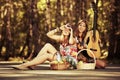 Two young fashion girls with guitar in a summer forest Royalty Free Stock Photo