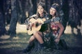 Two young fashion girls with guitar in a summer forest Royalty Free Stock Photo