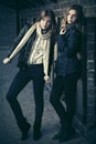 Two young fashion girls next to brick wall Royalty Free Stock Photo