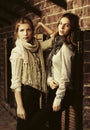 Two young fashion girls next to brick wall Royalty Free Stock Photo