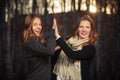 Two young fashion girls in black pullover and scarf walking outdoor Royalty Free Stock Photo