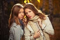 Two young fashion girls in white shirt and scarf in autumn park Royalty Free Stock Photo