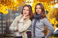 Two young fashion girls in white shirt and scarf walking in city street Royalty Free Stock Photo