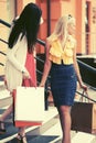 Two young fashion women with shopping bags on the mall steps Royalty Free Stock Photo