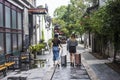 Two young fashionable girls walking with suitcases in the old gate east scenic area