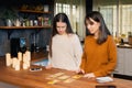 Two young femaies nervous about using tarot cards in a family kitchen Royalty Free Stock Photo
