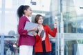 Two young female accountants walk and talk in front of the building\'s office.