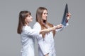 Two young female doctors looking at the x-ray picture of lungs on grey background Royalty Free Stock Photo