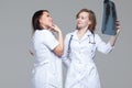 Two young female doctors studying the x-ray picture of lungs on grey background Royalty Free Stock Photo