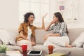 Two young female friends with coffee conversing Royalty Free Stock Photo