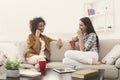 Two young female friends with coffee conversing Royalty Free Stock Photo