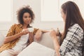 Two young female friends with coffee conversing Royalty Free Stock Photo