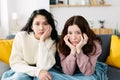 Two young female friends getting bored watching movie or television