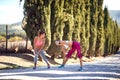 Two young female friends stretching, worming up before jogging, looking each other, smiling Royalty Free Stock Photo