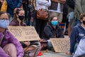 Two young female protestors sitting on the floor.