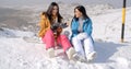 Two young female snowboarders enjoying a chat