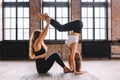 Two young females do complex of stretching yoga asanas in loft style class. Training, handstand
