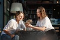 Two young females using smartphone in a cafe outdoors sitting in a cafe with coffee Royalty Free Stock Photo