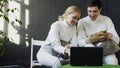 Two young fencers man and woman watching fencing tutorial on laptop computer and sharing experience before training