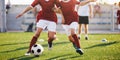 Two young football players running the ball. Soccer players compete in the training games