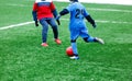 Two young Footballers in red and blue sportswear running,dribble and competing for ball. Junior football match competition. Winter