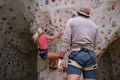 Two young friends climbing a wall on artificial rock climbing wall indoors