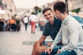 Two young friends talking together on a city street Royalty Free Stock Photo