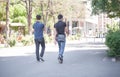 Two young friends wearing protective masks walking in the street