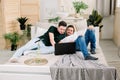 Two young gay men lying on the bed and using a laptop. Handsome gay men spending time together. Homosexual couple, gay Royalty Free Stock Photo