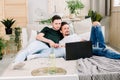 Two young gay men lying on the bed and using a laptop. Handsome gay men spending time together. Homosexual couple, gay Royalty Free Stock Photo