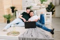 Two young gay men lying on the bed and using a laptop. Handsome gay men spending time together. Homosexual couple, gay Royalty Free Stock Photo