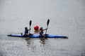 Two young girl athletes are sailing canoe on river, controlling oars. Active outdoor sports training. Side view. Copy space.
