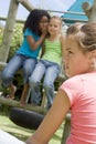 Two young girl friends at a playground whispering Royalty Free Stock Photo